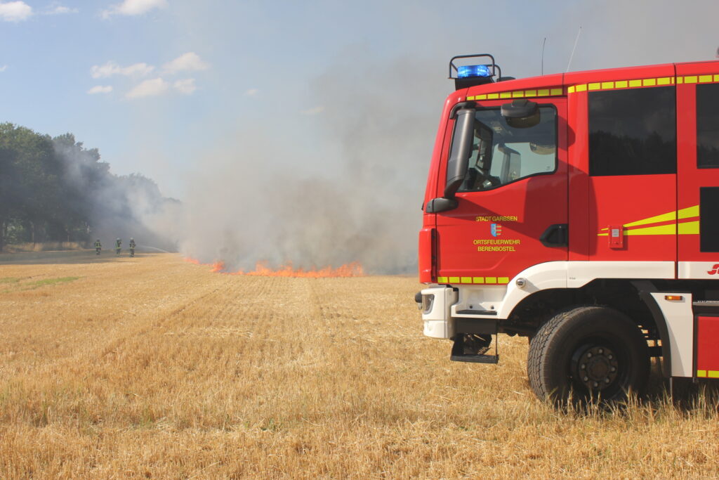 Ballenpresse und Stoppelfeld stehen in Flammen